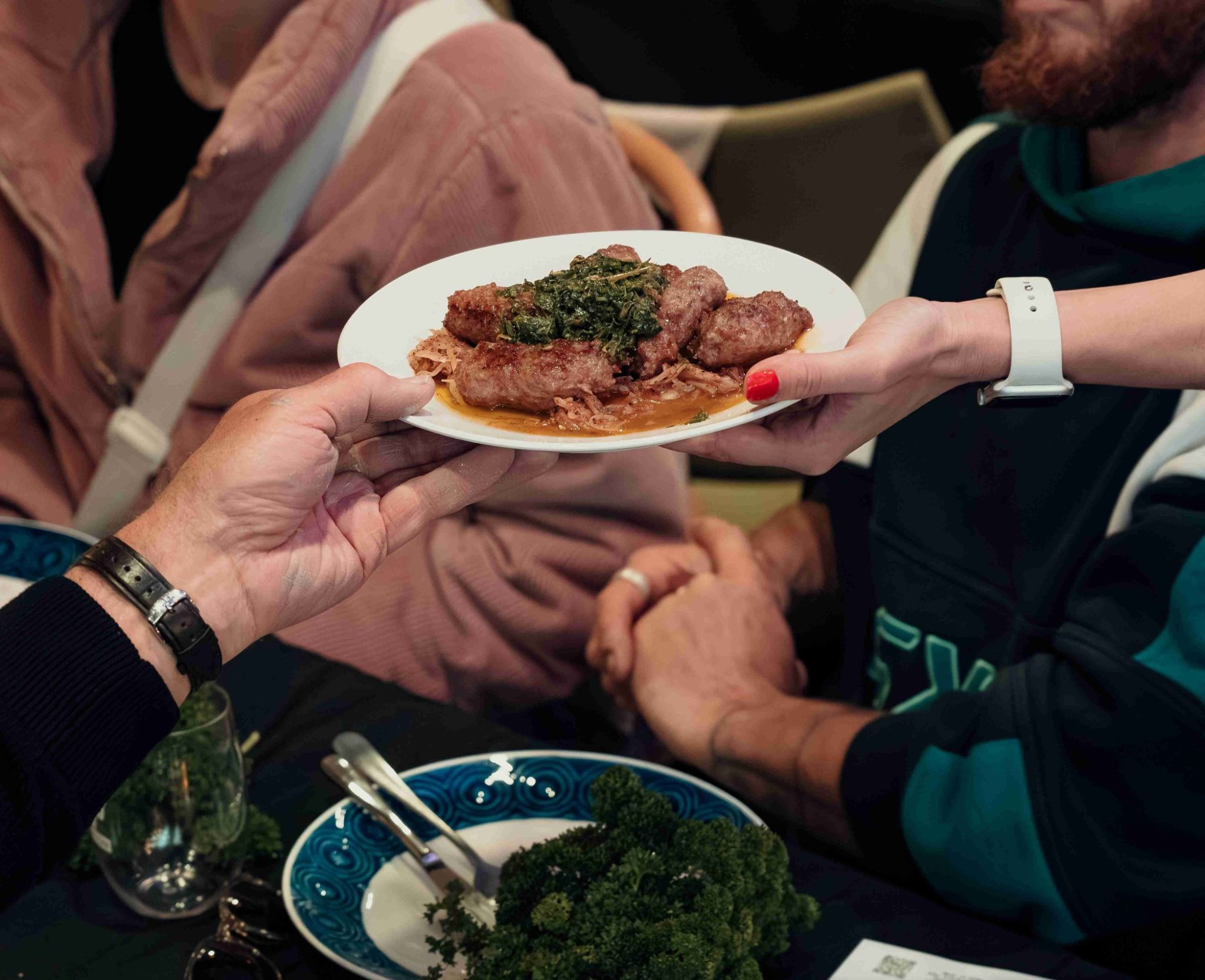 Two hands hold a plate of food.